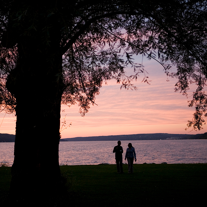 Students enjoy the view of Cayuga Lake at sunset in Stewart Park.