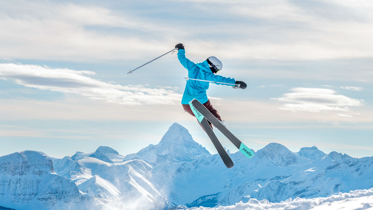 Skier mid-jump on a tall mountain.